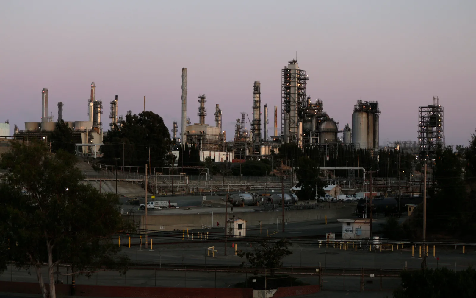 A large petroleum refinery facility with multiple processing towers, pipelines, and industrial structures typical of California's oil and gas infrastructure